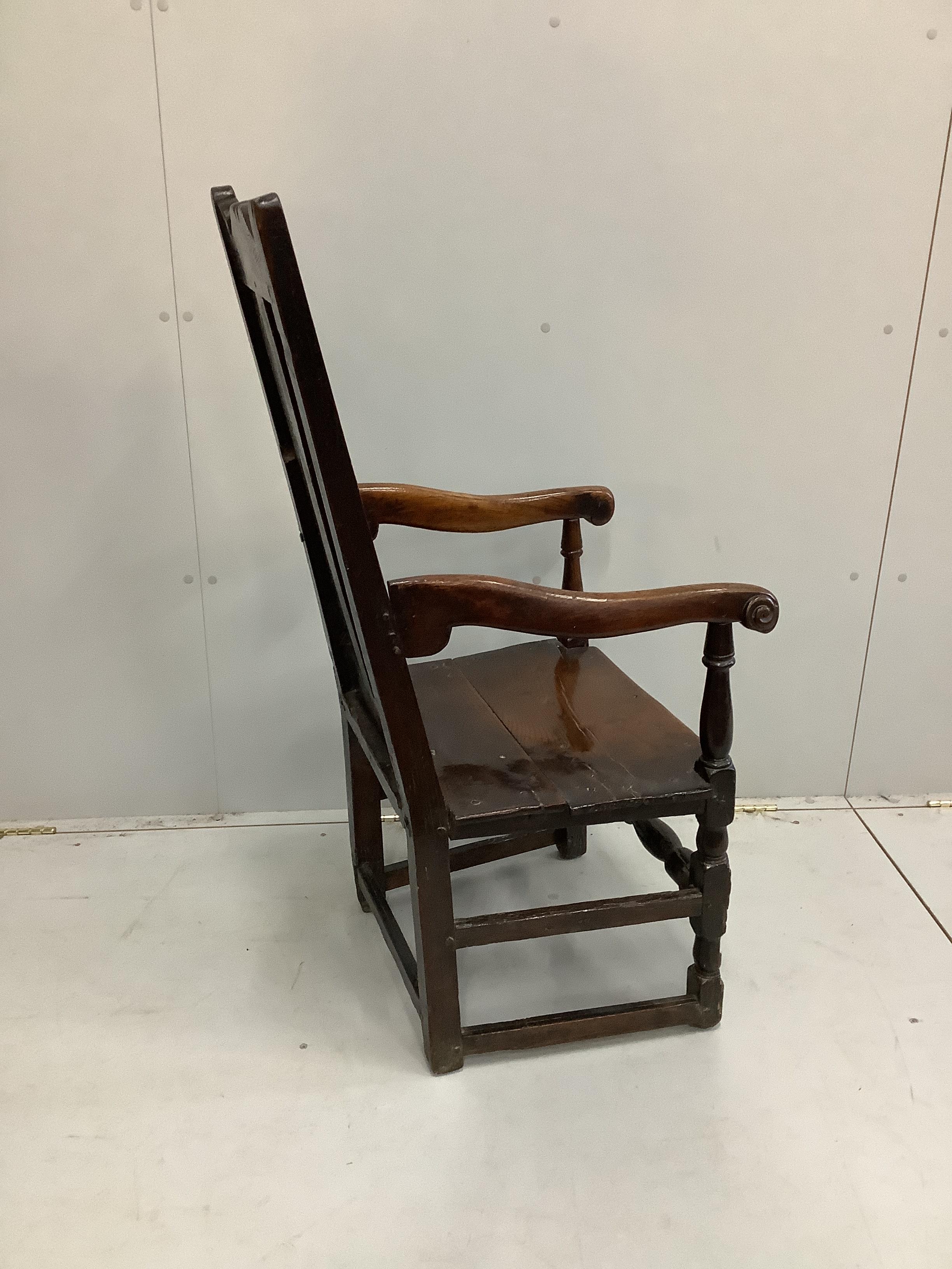 An 18th century oak elbow chair with twin panelled back, width 52cm, depth 50cm, height 110cm